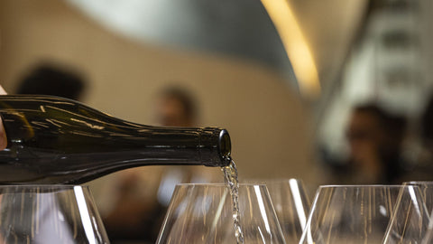 Servicio de vino blanco en copas durante una cata en un restaurante